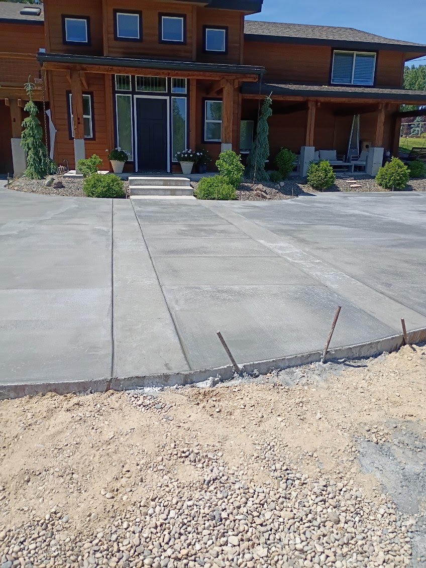 Curved concrete driveway with entry walkway in Idaho